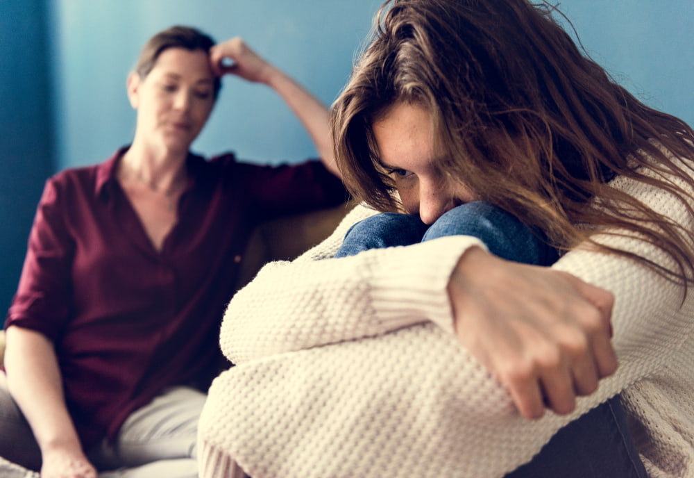 mother and daughter mid-argument with daughter looking upset and mother looking frustrated