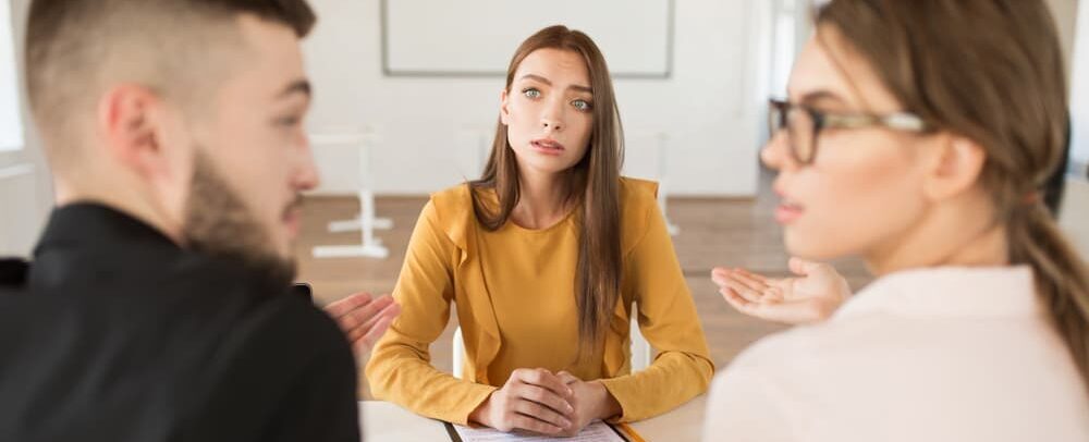 A woman lawyer speaks to a men and a woman in a meeting discussing the chances of winning a divorce appeal.