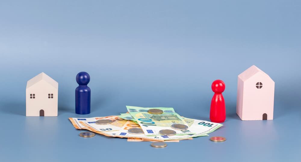 Image of a house and cash on a blue backdrop, representing women's empowerment in achieving financial independence post-divorce.