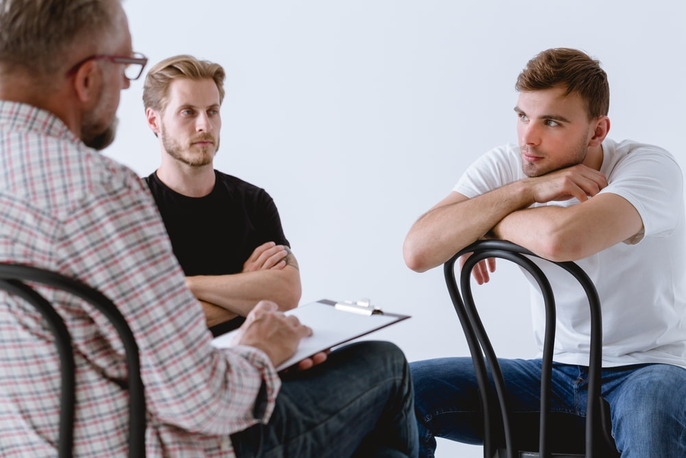 group of seated men gathered in a circle supporting each other through divorce