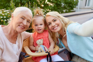 concept - happy mother, daughter and grandmother taking selfie at cafe or restaurant terrace