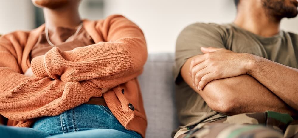 A man and woman sit together on a couch, discussing military divorce matters in Grand Rapids.