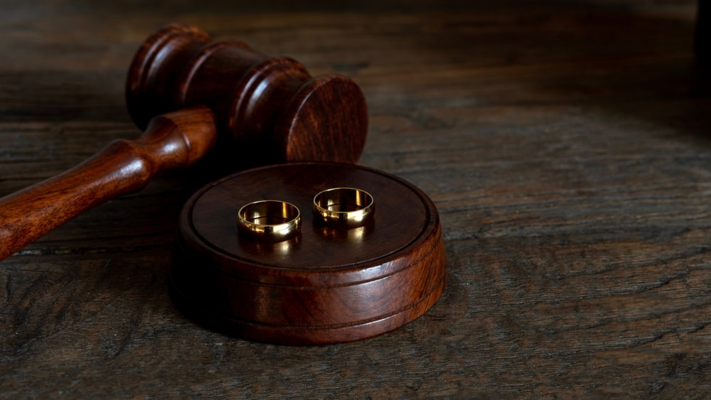 gold wedding bands laid on top of a gavel